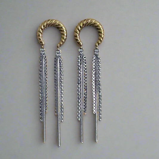 Pair of gold and silver earrings with braided tops on a light gray background
