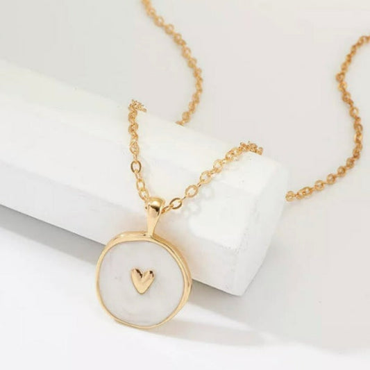 Beautiful, gold necklace with a coin pendant, white enamel and a gold heart in the center